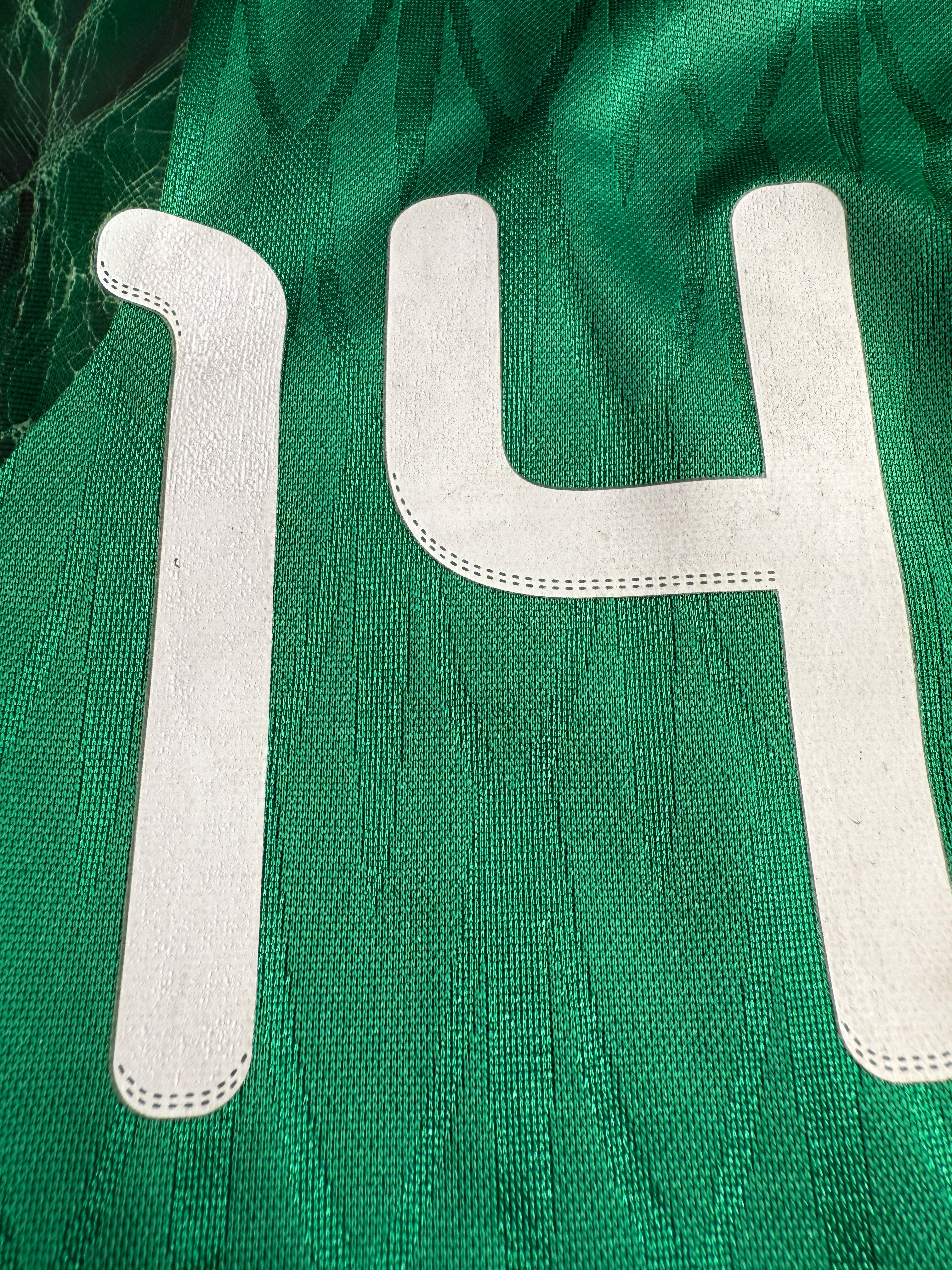 Close-up of a green garment with white lettering and design.