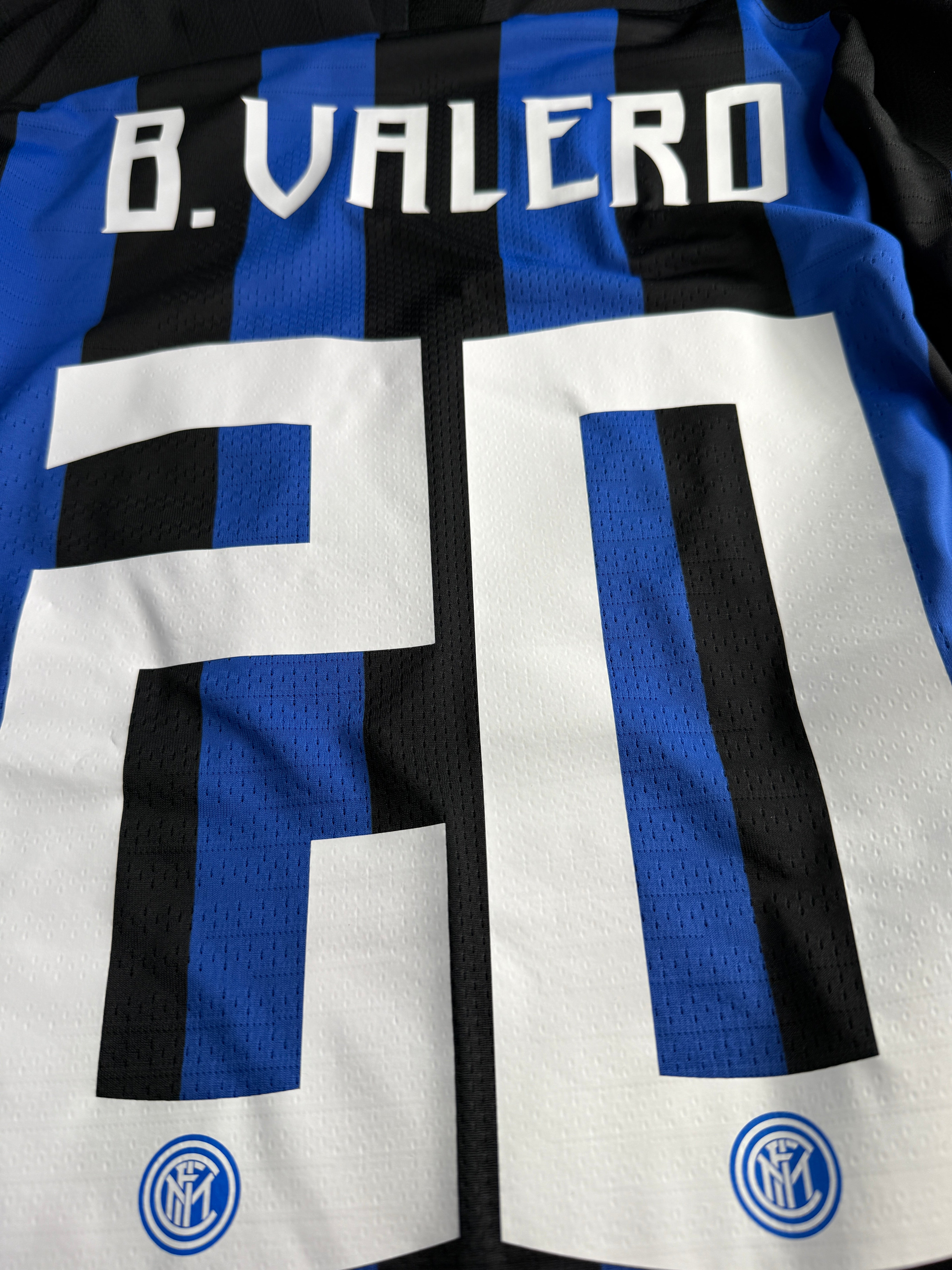 Close-up of a sports jersey with blue and white design and logo.