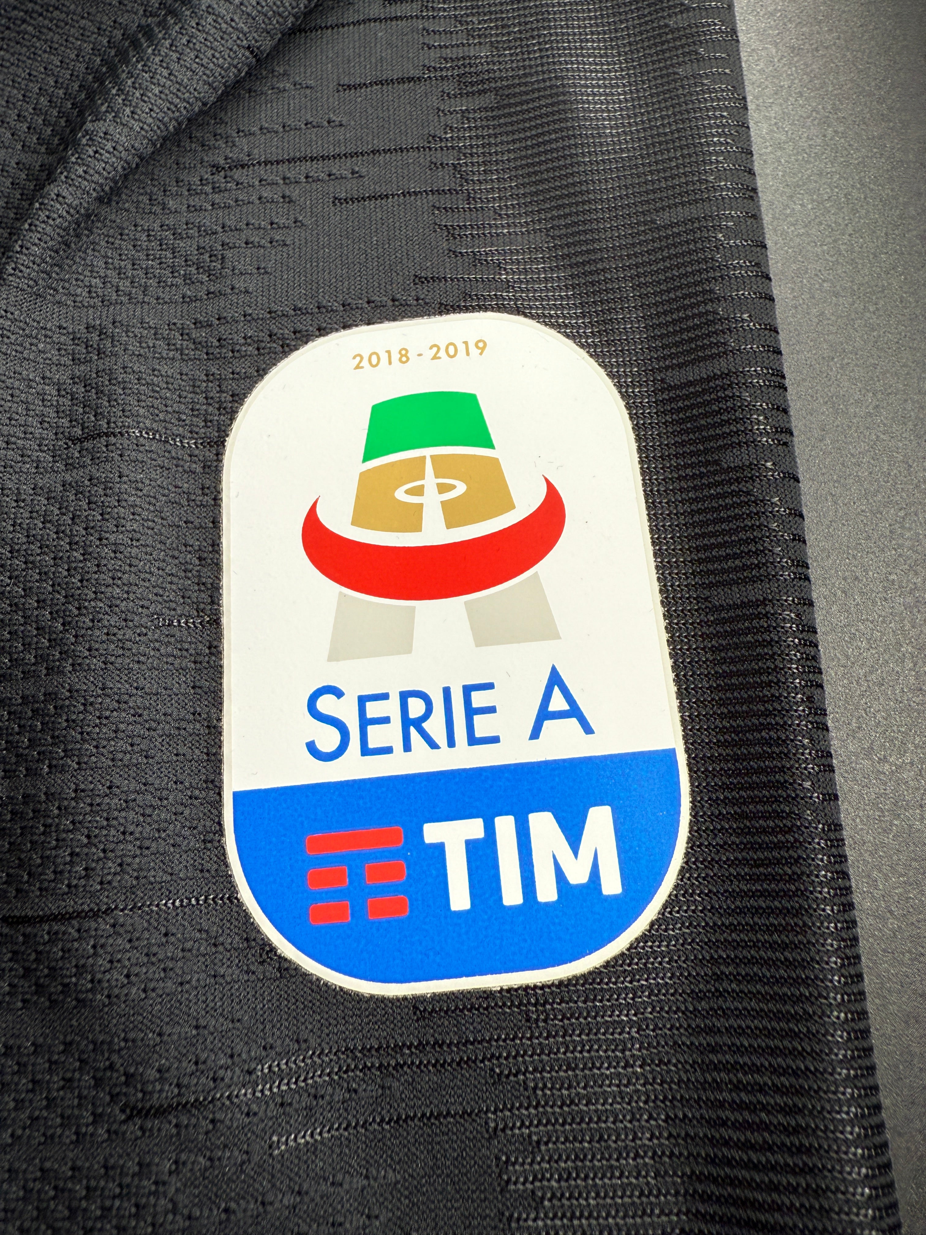 Serie A TIM logo on a black sports jersey