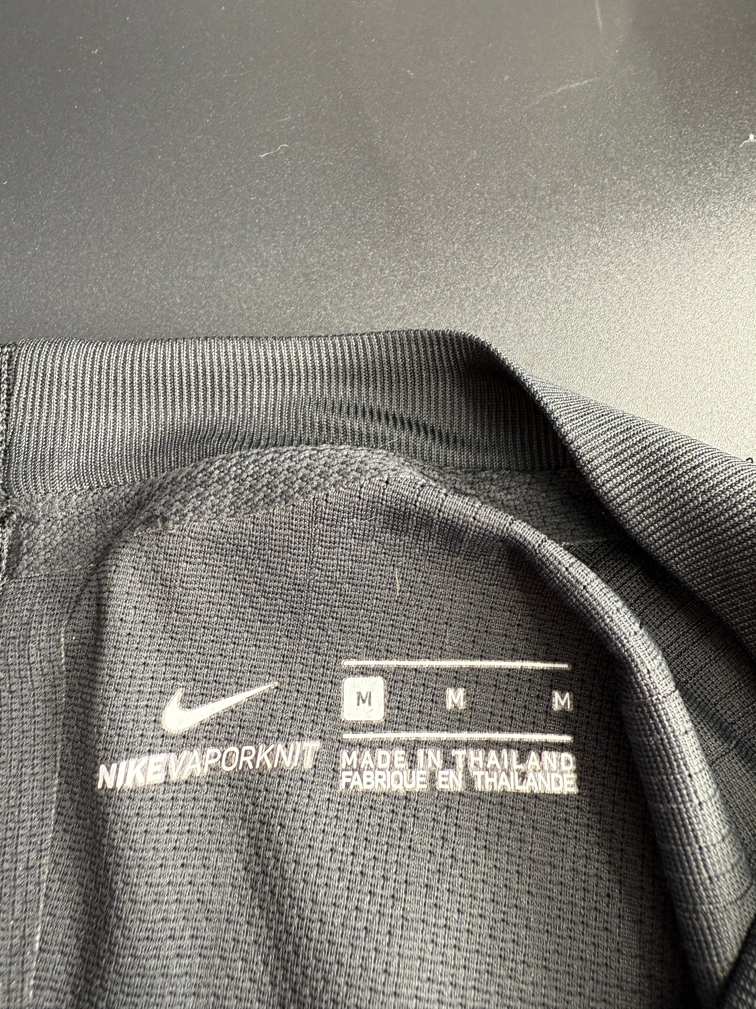 Close-up of a gray hoodie with a label and logo.