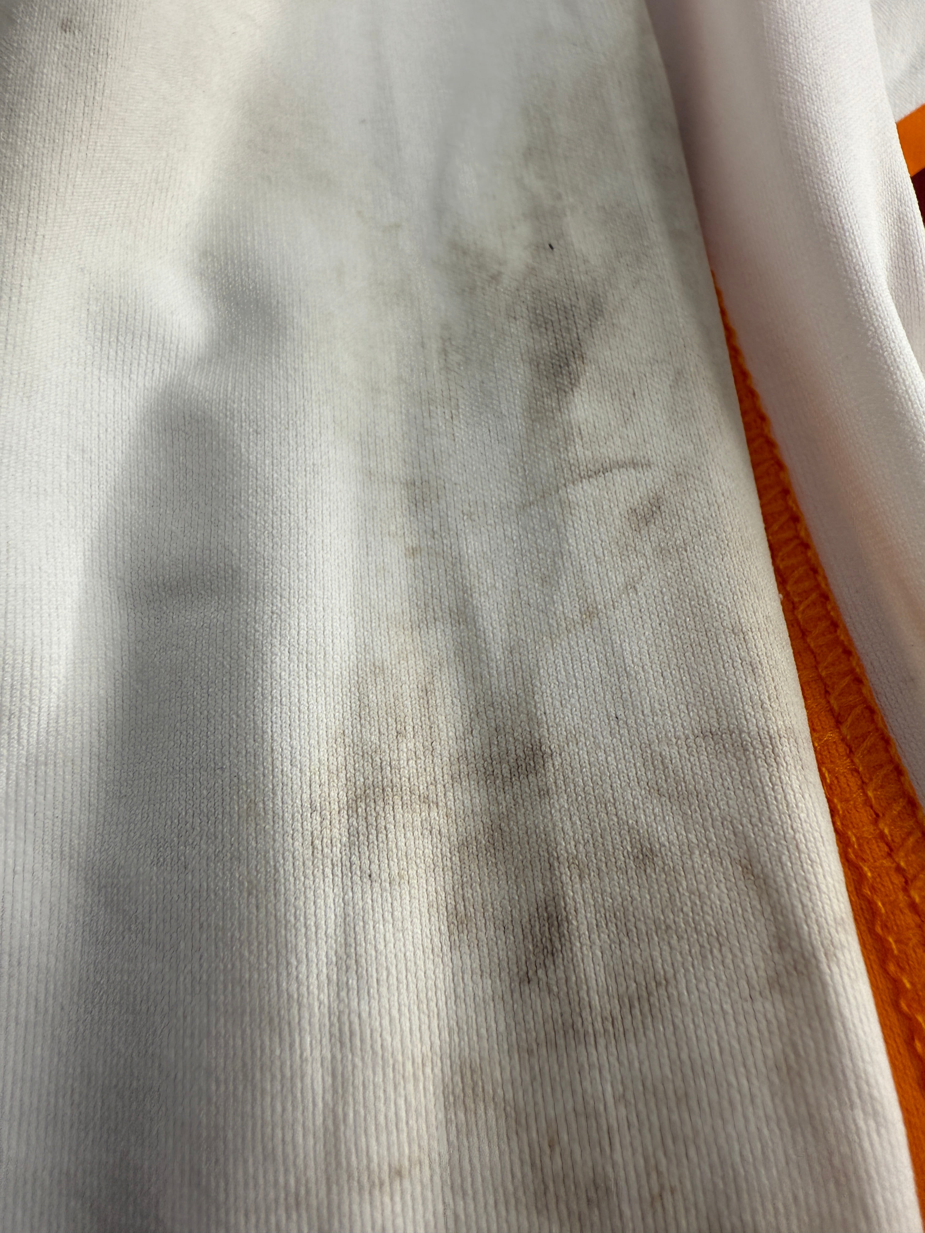 Close-up of textured white fabric with orange background