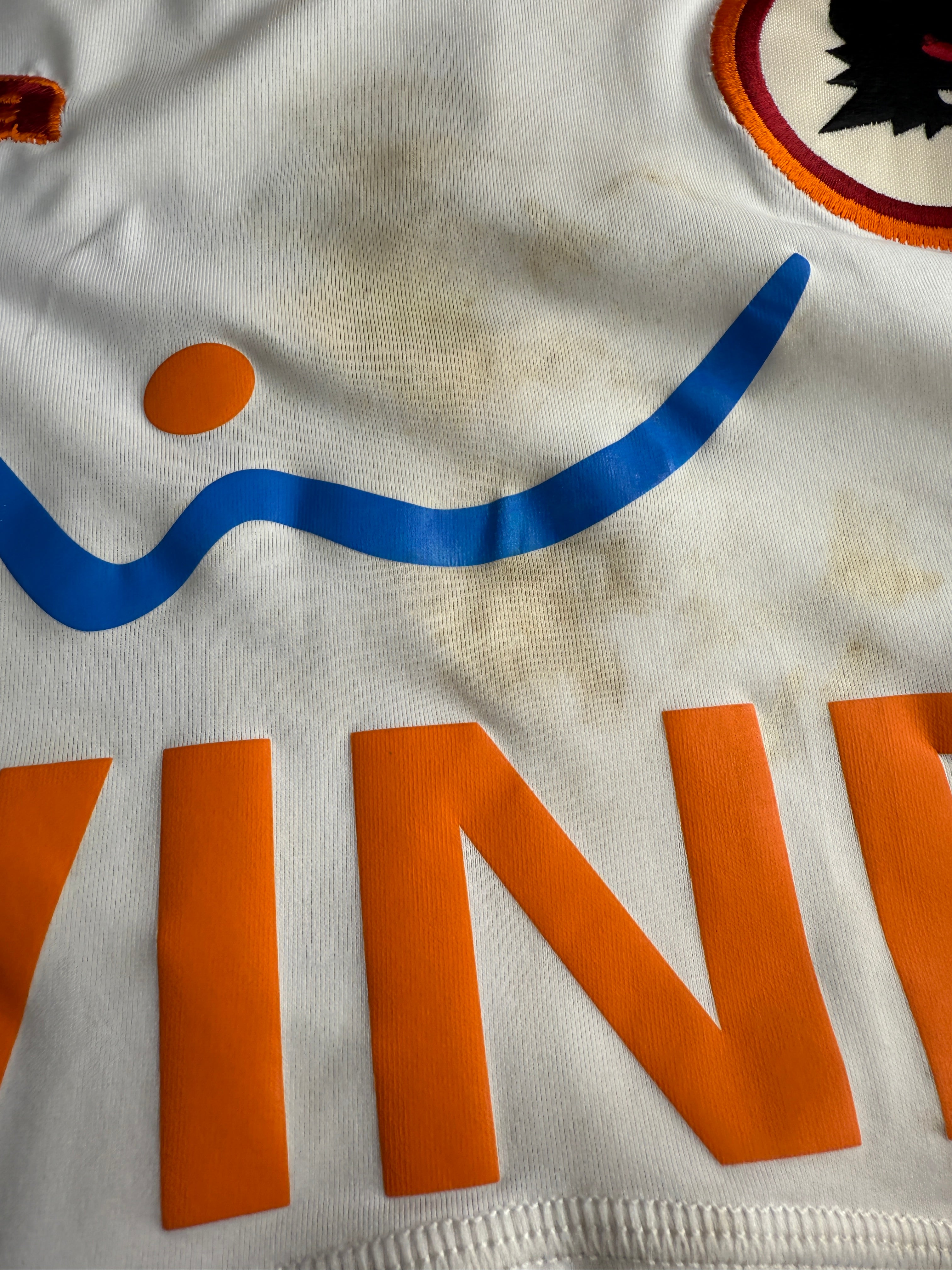 Close-up of a sports jersey with orange and blue details.
