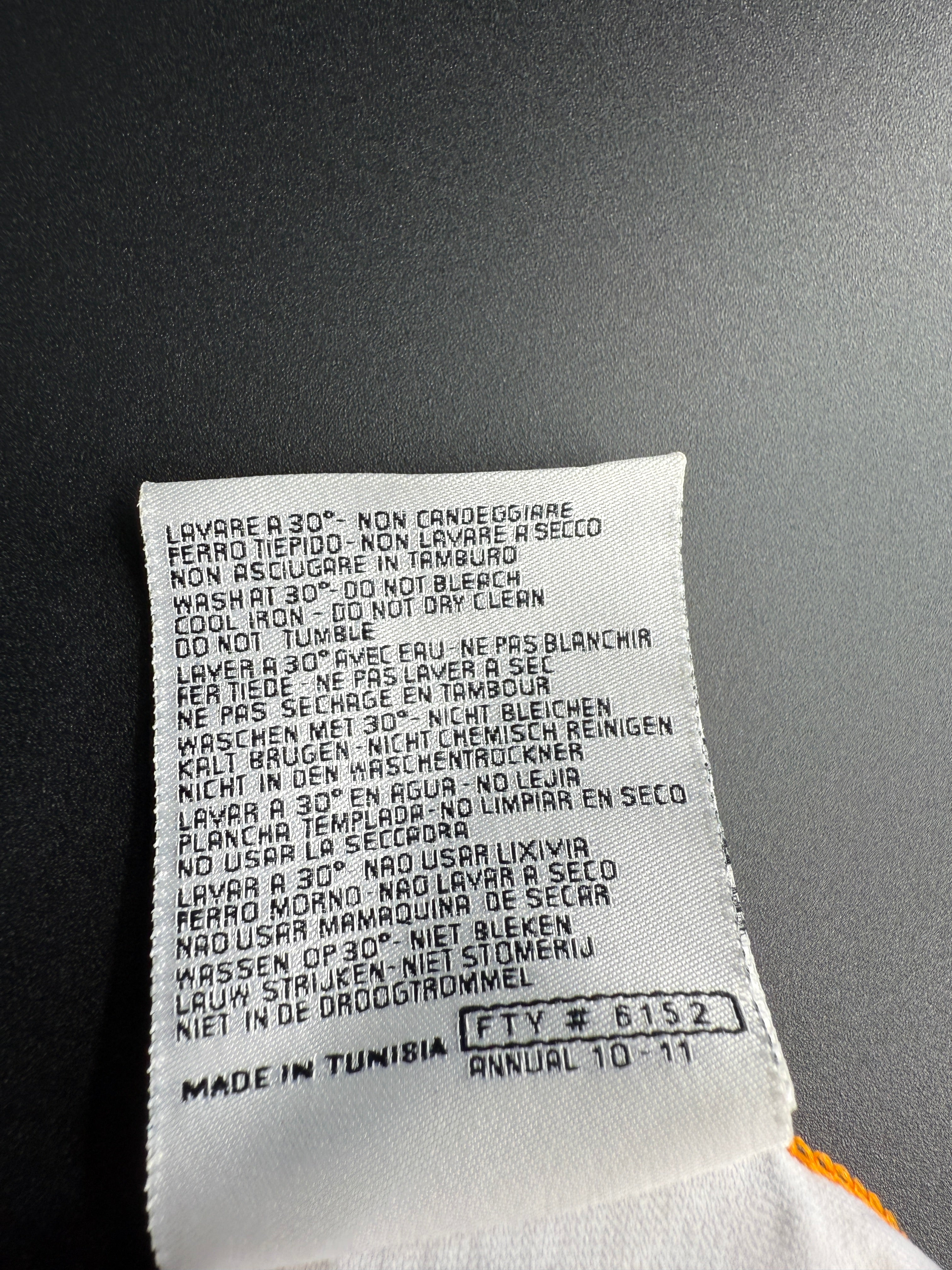 Close-up of a fabric label with text on a black background.