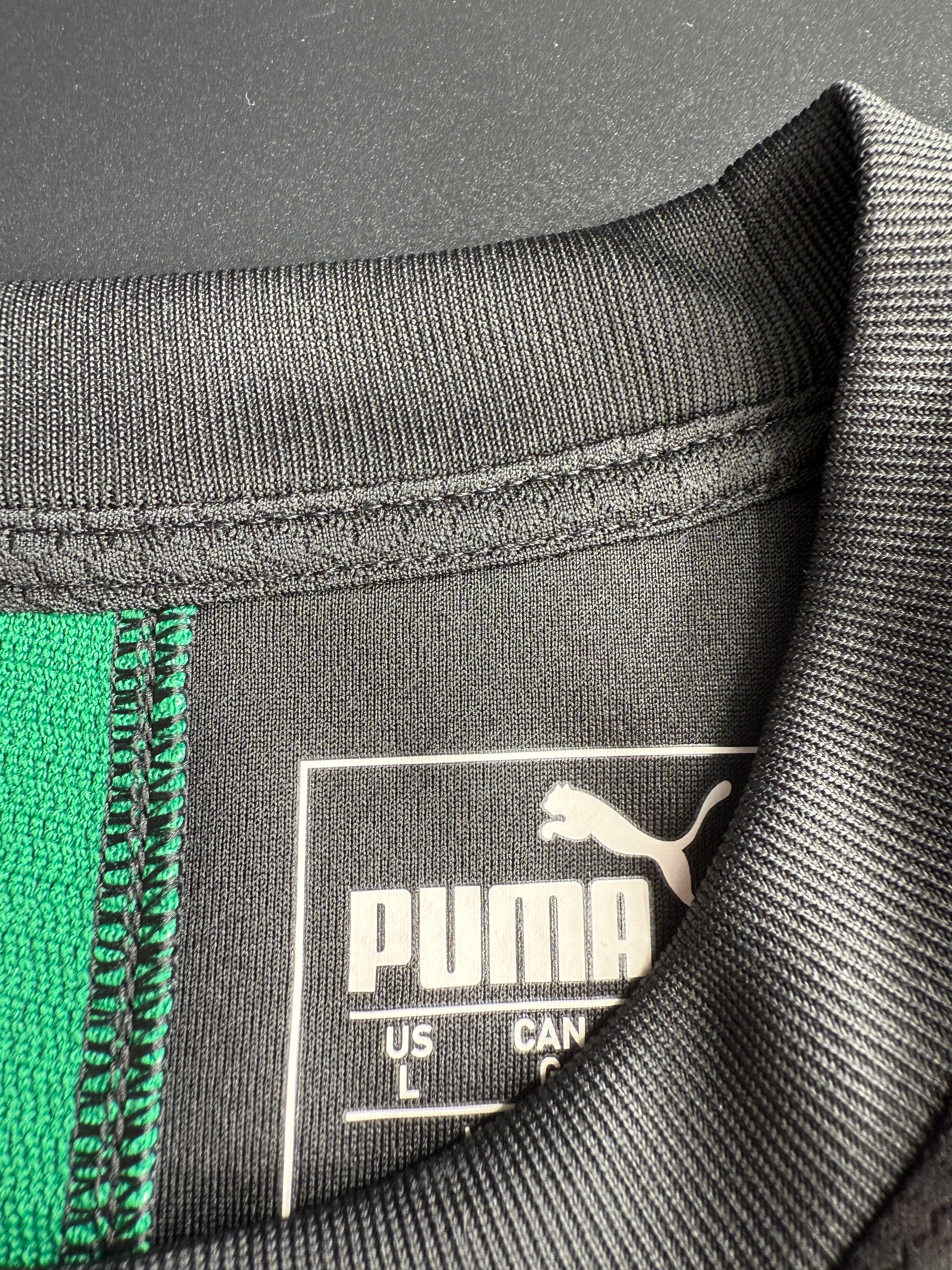 Close-up of a label on a piece of clothing with a zipper and green fabric.
