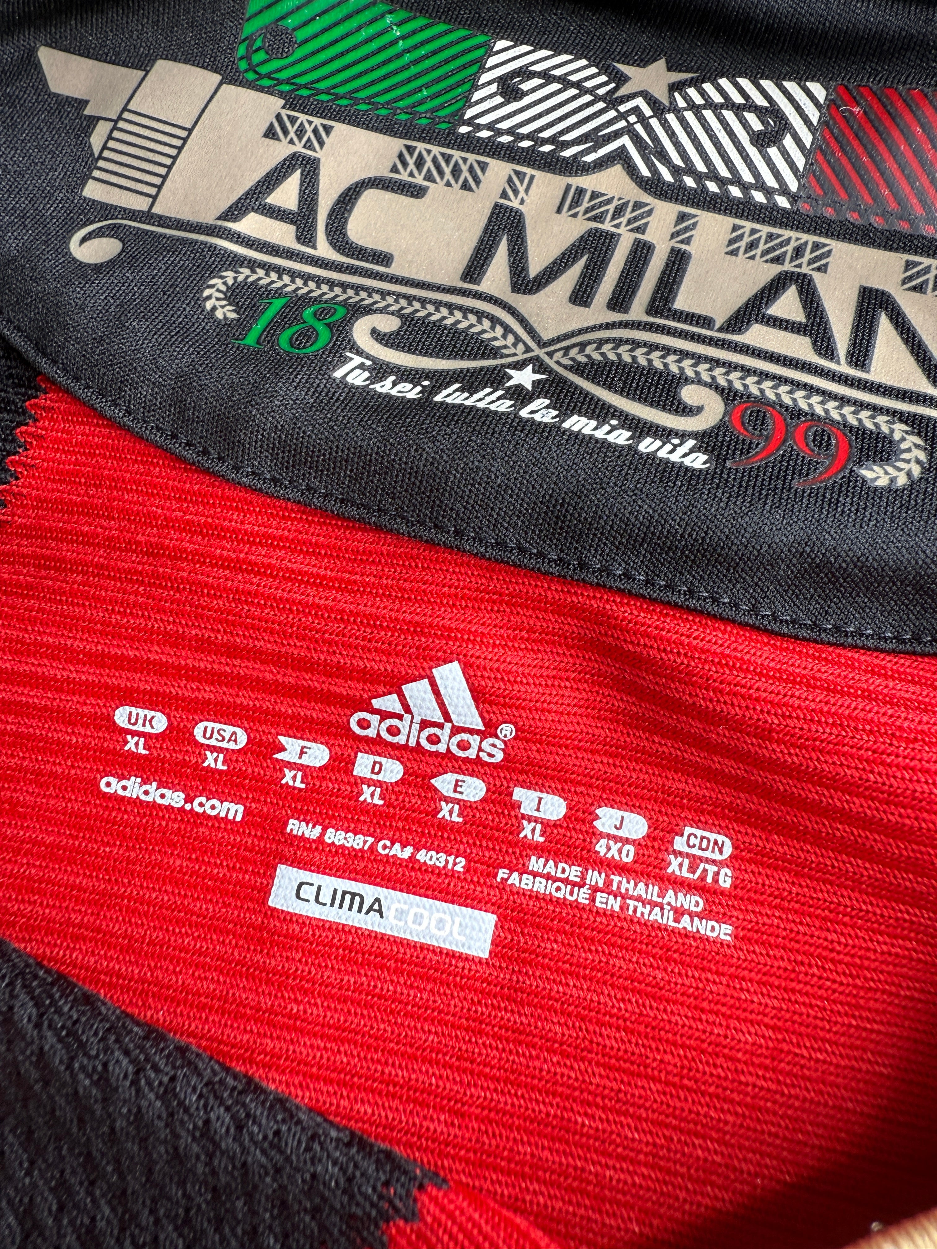 Close-up of AC Milan sports jersey with branding and text details.