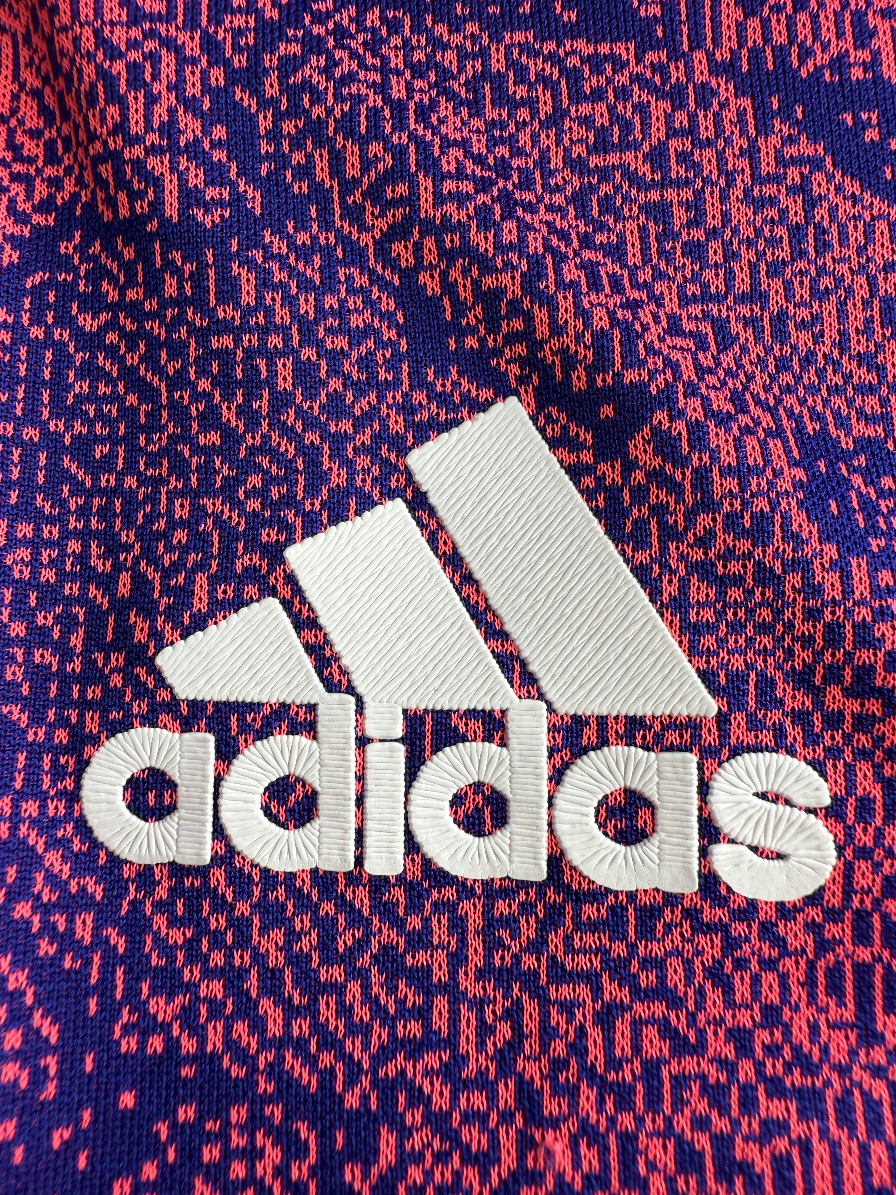 White Adidas logo on a red and blue patterned background