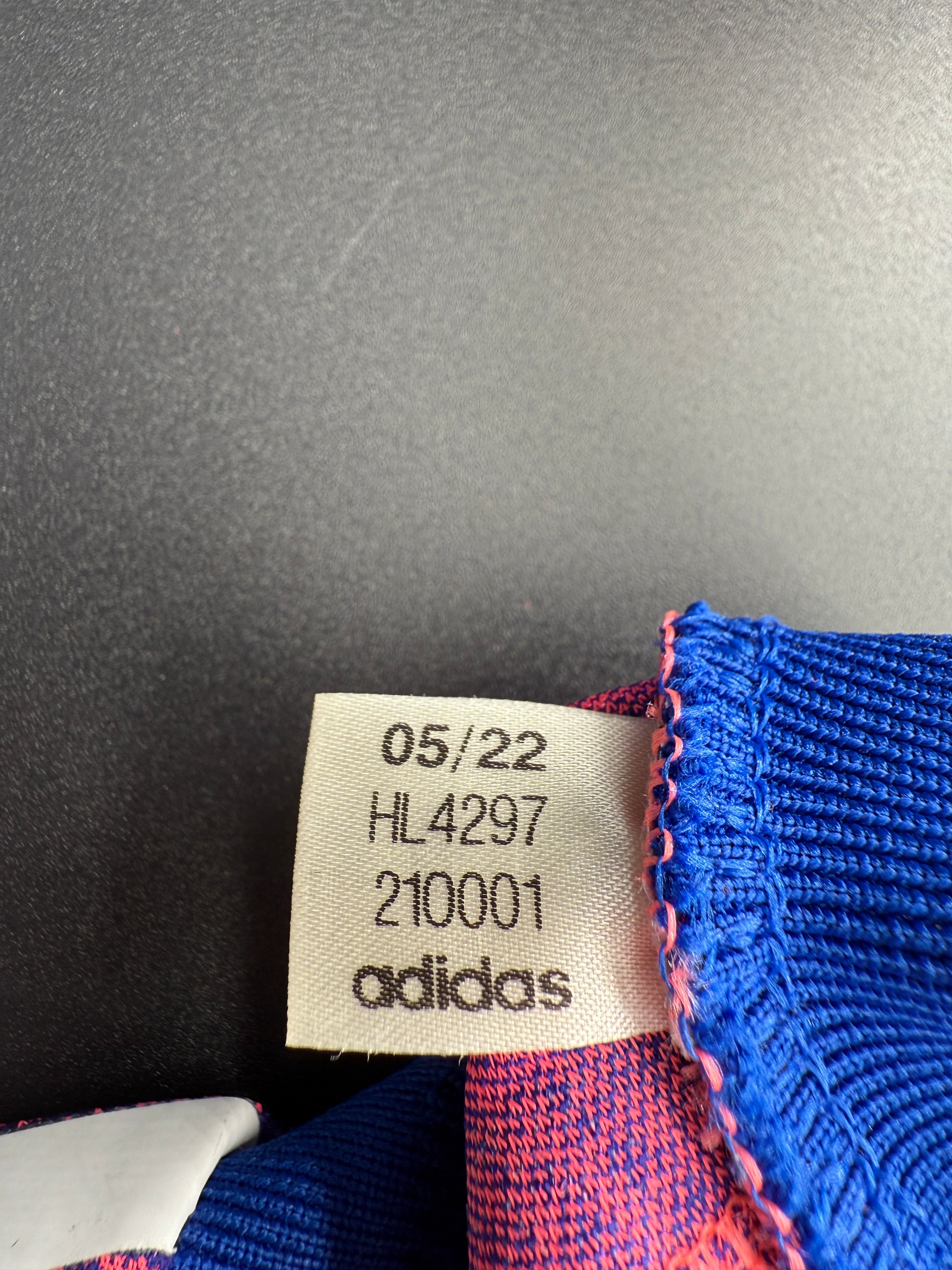 Close-up of a fabric tag with text and numbers on a textured background.