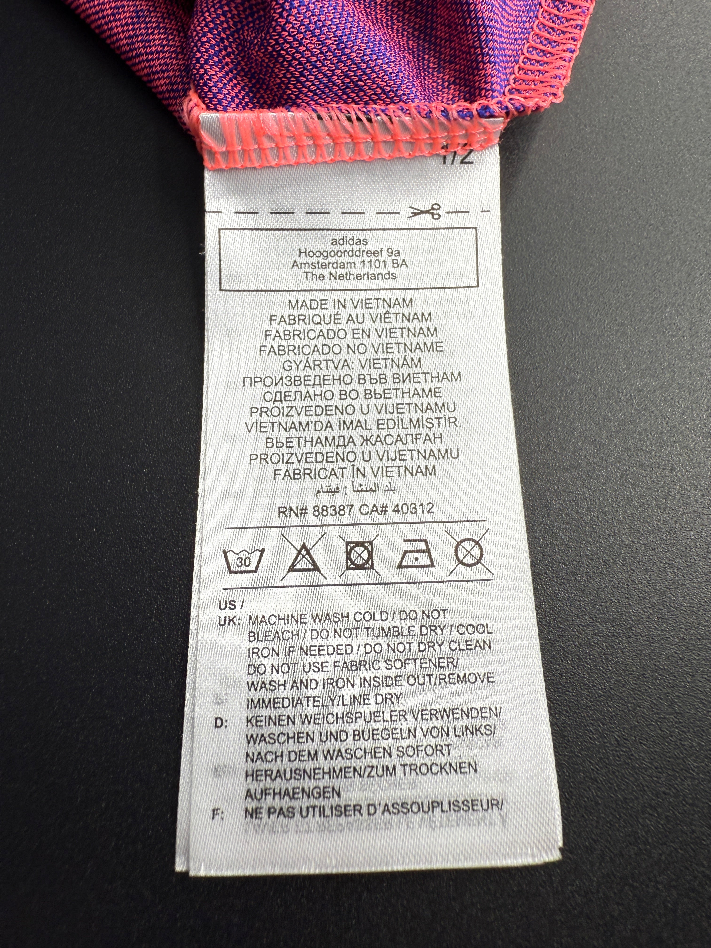 Close-up of a fabric label with text and symbols on a dark background.